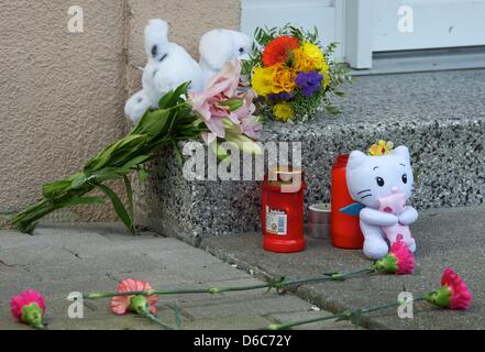 Fleurs et animaux en peluche se trouvent en face d'une entrée indépendante à Grimma, Allemagne, 04 septembre 2012. Après un bébé a eu une chute mortelle d'une fenêtre le ministère public se concentre ses enquêtes sur la mère de 24 ans. Le bébé de cinq semaines est tombé du 4ème étage d'un immeuble le 03 septembre 2012. Ni un accident ni comme crime pourrait être exclu une Banque D'Images