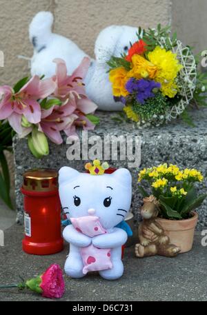 Fleurs et animaux en peluche se trouvent en face d'une entrée indépendante à Grimma, Allemagne, 04 septembre 2012. Après un bébé a eu une chute mortelle d'une fenêtre le ministère public se concentre ses enquêtes sur la mère de 24 ans. Le bébé de cinq semaines est tombé du 4ème étage d'un immeuble le 03 septembre 2012. Ni un accident ni comme crime pourrait être exclu une Banque D'Images