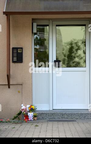 Fleurs et animaux en peluche se trouvent en face d'une entrée indépendante à Grimma, Allemagne, 04 septembre 2012. Après un bébé a eu une chute mortelle d'une fenêtre le ministère public se concentre ses enquêtes sur la mère de 24 ans. Le bébé de cinq semaines est tombé du 4ème étage d'un immeuble le 03 septembre 2012. Ni un accident ni comme crime pourrait être exclu une Banque D'Images