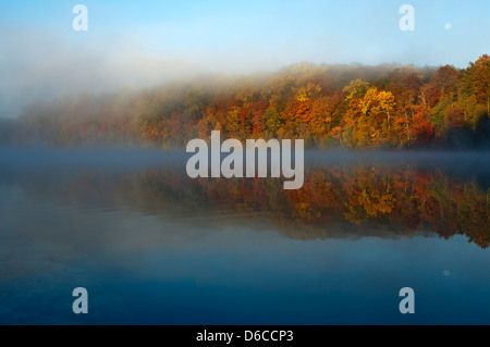Un beau matin d'automne brumeux avec des réflexions de feuillage coloré sur un lac encore Banque D'Images