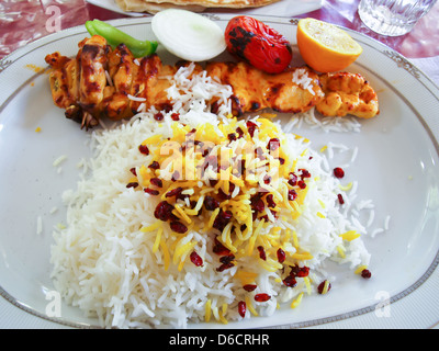 Un iranien du poulet grillé et tomates servi sur le riz blanc en plaque en céramique Banque D'Images