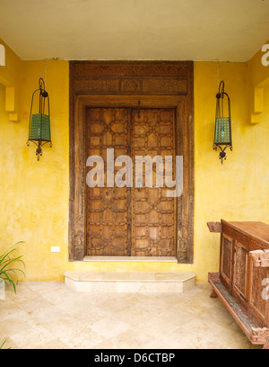 Mobilier de style marocain et porte en bois sur mur jaune Banque D'Images