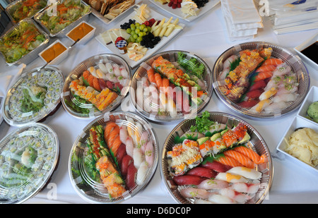 Sushi, sashimi, rolls sur des plateaux et des collations froides en préparation pour un travail sur table buffet, restauration Banque D'Images