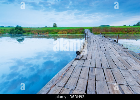 Pont de bois sur un petit lac au petit matin Banque D'Images