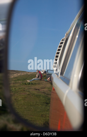 Les gens sous l'ancienne VW camper van wing mirror. Banque D'Images