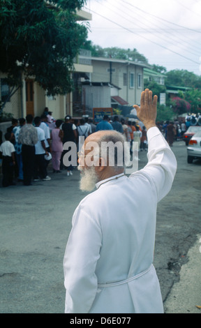 Tobago Scarborough Priest Holding Up la main pour arrêter le trafic lors de Procession du Corpus Christi Banque D'Images