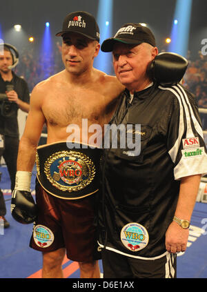 Boxeur allemand Arthur Abraham (L) pose avec l'entraîneur Ulli Wegner après avoir remporté le super-WBO Europe Championnat de poids moyen de lutte entre Abraham et boxeur Argetnine Farias au Baden Arena à Offenburg, Allemagne, 14 janvier 2012. Photo : Patrick Seeger Banque D'Images