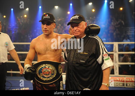 Boxeur allemand Arthur Abraham (L) pose avec son entraîneur Ulli Wegner après avoir remporté le super-WBO Europe Championnat de poids moyen de lutte entre Abraham et boxeur Argetnine Farias au Baden Arena à Offenburg, Allemagne, 14 janvier 2012. Photo : Patrick Seeger Banque D'Images