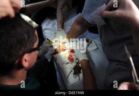 Attention CERTAINES DE CES IMAGES CONTIENNENT LE CONTENU GRAPHIQUE DARKOUSH, SYRIE : Don de l'aider les médecins qui s'occupent d'un jeune homme qui a été torturé à plusieurs reprises le 15 avril 2013, à Darkoush, la Syrie. 45 médecins sud-africains sont en Syrie, en collaboration avec le don de l'organisation de l'aide de soignants d'un hôpital local. (Photo par Gallo Images / Photos / Felix24 Dlangamandla) Banque D'Images