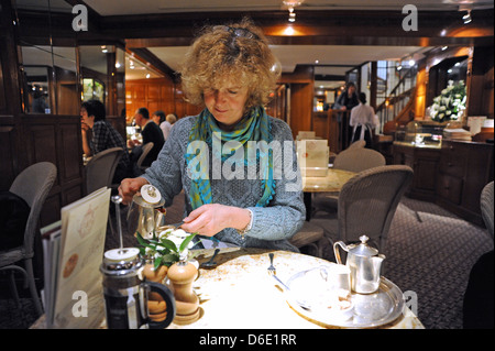 Woman enjoying pot de thé à Bettys Cafe Salons de thé dans la chambre, en bas, à York Yorkshire UK Banque D'Images