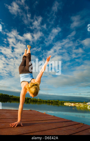 Caucasian woman practicing yoga on dock sur le lac encore, Anchorage, Alaska, United States Banque D'Images