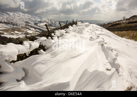 L'empreinte relevée dans les amoncellements de neige massives de bloquer l'Kirkstone Pass Road au-dessus de Ambleside dans le Lake District, Banque D'Images