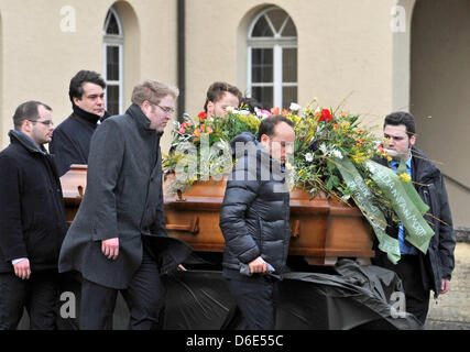 Les porteurs et en deuil accompagner le cercueil du ministère public qui a été assassiné à Dachau la cour de district de sa tombe au cimetière du nord à Munich, Allemagne, le 19 janvier 2012. Un homme abattu les 31 ans au cours d'un procès le 11 janvier 2012. Photo : Andreas GEBERT Banque D'Images