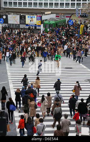 Scène de rue japonais montrant des foules de gens qui traversent la rue sur un passage pour piétons à Shibuya, Tokyo, Japon Banque D'Images