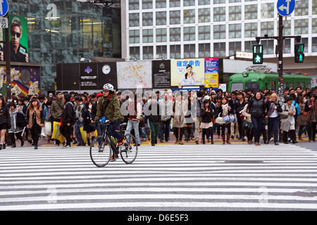 Scène de rue japonais montrant des foules de gens qui traversent la rue sur un passage pour piétons à Shibuya, Tokyo, Japon Banque D'Images