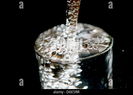 Fichier - ILLUSTRATION - illustration d'une archive photo datée du 30 janvier 2003 montre l'eau potable et verser dans un verre à Cologne, Allemagne. L'eau potable de l'Allemand waterworks est presque toujours impeccable. C'est le résultat du dernier rapport sur la qualité de l'eau potable par le ministère de la Santé allemand et l'Agence fédérale de l'environnement (UBA). Photo : Oliver Berg Banque D'Images