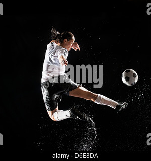 Le joueur de soccer hispaniques splashing in water Banque D'Images