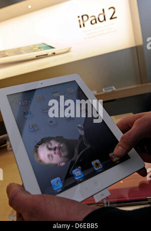 (Afp) - Une archive photo, datée du 25 mars 2011, montre un iPad2 clients l'examen d'une tablette d'ordinateur dans un Apple Store à Munich, Allemagne. Apple a annoncé ses résultats du 1er trimestre de l'année d'affaires le 24 janvier 2012. Photo : Andreas Gebert Banque D'Images