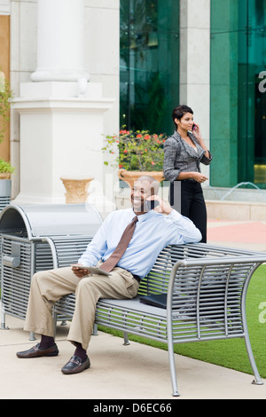 Business people talking on cell phones outdoors Banque D'Images