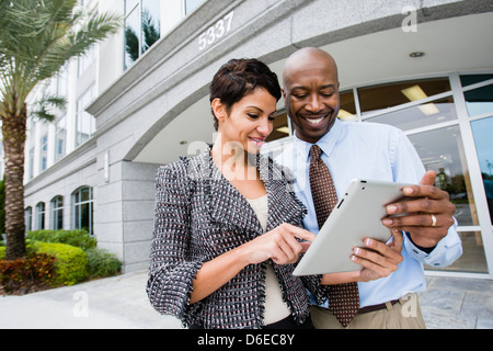 Business people using tablet computer outdoors Banque D'Images