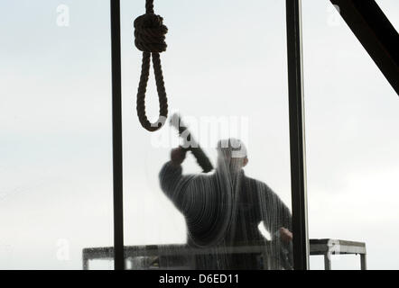 Un nettoyant pour vitres nettoie une fenêtre derrière un nœud coulant au Musée pour la culture sépulcral à Kassel, Allemagne, 25 janvier 2012. L'exposition 'Potence, Roue et jeu" est ouvert du 28 janvier 2012. Photo : Uwe Zucchi Banque D'Images