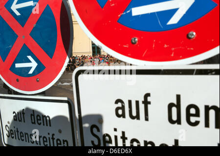 Les gens s'asseoir dans un café derrière les panneaux de circulation à la place de l'Odéon à Munich, Allemagne, le 25 janvier 2012. Malgré les températures froides, les gens profiter du beau temps à Munich. Photo : Peter Kneffel Banque D'Images