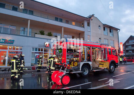 Les pompiers se tenir en face d'une maison à Langenfeld, Allemagne, 27 janvier 2012. Une famille avec deux enfants sont morts dans l'incendie d'un appartement le 27 janvier 2012. Selon la police, les parents ont 33 et 34 ans et les enfants de 1 et 5 ans d'âge. Photo : Ralph Matzerath Banque D'Images