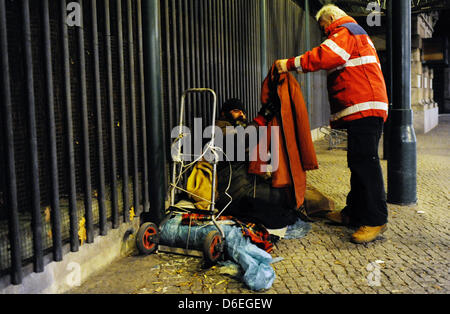 Un membre du personnel de la Croix-Rouge allemande aide froide prend soin d'un sans-abri dormant dans la rue à Berlin, Allemagne, 30 janvier 2012. L'abris d'urgence sont entièrement réservées. La demande de places est même supérieure à l'offre actuelle. Photo : Maurizio Gambarini Banque D'Images