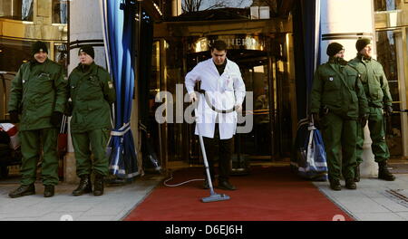 Von Reinigungspersonal staubsaugt Ein Mann am Freitag (03.02.2012) à München (Oberbayern) am ersten Tag der 48. Sicherheitskonferenz am Eingang des hôtels Bayerischer Hof den Roten Teppich zwischen den Nachts An Der Anlagestelle der. An der Konferenz, die vom 3. bis zum 5. Februar geht, nehmen mehr als 350 Gäste teil, darunter und Regierungschefs Ministre 60. aus der ganzen Welt. Foto : Tobias a Banque D'Images