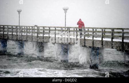 Un homme marche dans une jetée à la mer Baltique À Haffkrug, tandis qu'il neige, Allemagne, 03 février 2012. La neige et la glace noire sur les piétons et le trafic en Allemagne. Photo : Carsten Rehder Banque D'Images