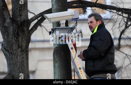 Ein Mann befestigt am Freitag (03.02.2012) à München (Oberbayern) am ersten Tag der 48. Sicherheitskonferenz vor dem Hotel Bayerischer Hof eine Überwachungskamera une einem Baum vor dem Hotel. An der Konferenz, die vom 3. bis zum 5. Februar geht, nehmen mehr als 350 Gäste teil, darunter und Regierungschefs Ministre 60. aus der ganzen Welt. Foto : Tobias Hase dpa/lby Banque D'Images