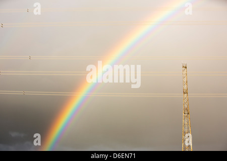 Un arc-en-ciel sur les pylônes électriques laissant nucléaire Wylfa sur l'Anglesey, au Pays de Galles, Royaume-Uni. Banque D'Images