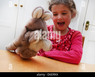 7 ans fille jouant avec Kangaroo Marionnette à main en Angleterre Banque D'Images