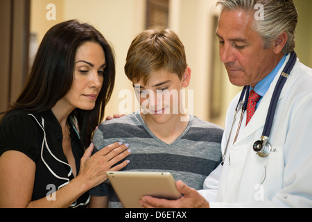Mère et fils using digital tablet avec dentiste Banque D'Images