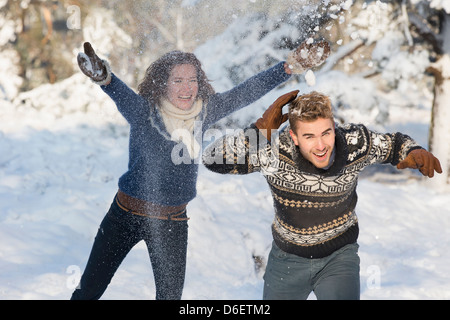 Caucasian couple jouent dans la neige Banque D'Images