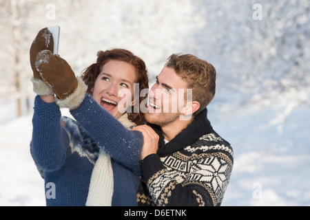 Couple à prendre des photos dans la neige Banque D'Images