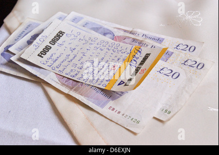 Une facture de restaurant pour €108,50 €120 avec paiement en €20 notes sur une nappe ( GBP sterling) Banque D'Images