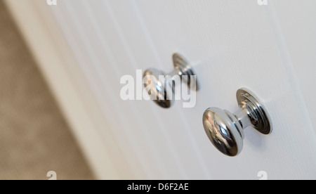 Close up de chrome sur les poignées de porte d'une armoire. Banque D'Images