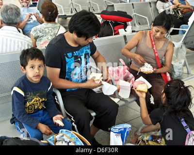 Famille avec 2 enfants mexicains : profitez de ad hoc malpropre déjeuner pique-nique dans la salle d'attente du terminal de bus de première classe Oaxaca Mexique Banque D'Images