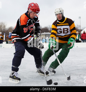 Deux hommes luttent pour la rondelle au cours d'une partie des Championnats mondiaux de hockey sur glace sur le lac Nokomis à Minneapolis, Minnesota. Banque D'Images