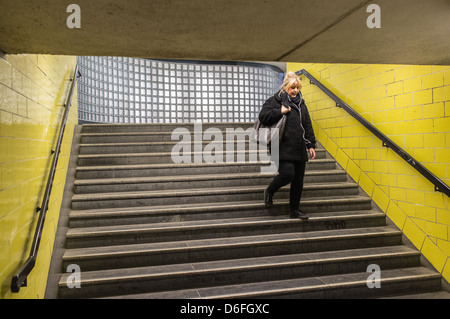 Woman walking down steps à une entrée de métro à Berlin, Allemagne Banque D'Images