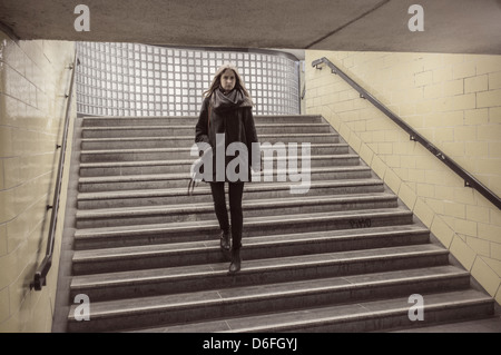 Woman walking down steps à une entrée de métro à Berlin, Allemagne Banque D'Images