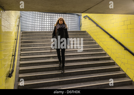 Woman walking down steps à une entrée de métro à Berlin, Allemagne Banque D'Images