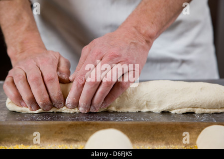 Cuisinier professionnel la préparation du pain frais dans une boulangerie commerciale Banque D'Images