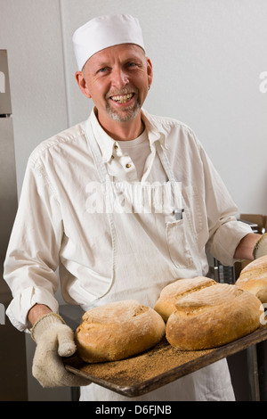 Cuisinier professionnel la préparation du pain frais dans une boulangerie commerciale Banque D'Images