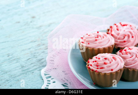 Cupcake chocolat pralines roses sur fond bleu vintage en bois avec copie espace Banque D'Images