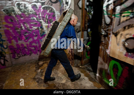 Fournisseur de charbon et de chauffage moyenne, Sascha Diesner, transporte les briquettes de charbon brun sur son dos à la cave d'un client, de Berlin, Allemagne, 09 février 2012. Il faut en général une semaine pour livrer le charbon et d'autres matériaux. En cas d'urgence, la société Hans Engelke Energie fournit à l'intérieur d'une journée. Photo : Robert Schlesinger Banque D'Images