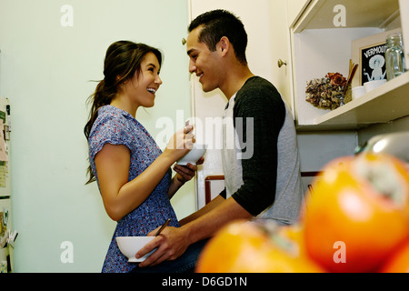 Smiling couple manger des céréales dans la cuisine Banque D'Images