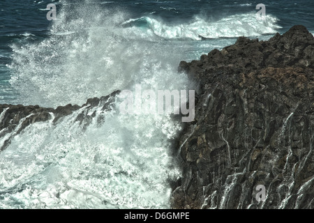 Éclaboussures des vagues de lave sur la côte rocheuse Banque D'Images