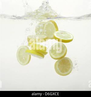 Les tranches de citron splashing in water Banque D'Images